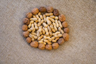 Fıstık ve ceviz yuvarlak şeklinde dizilmiş. Çiğ yuta tuval kırsal arkaplan.