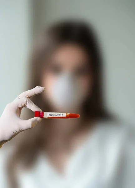 Cerrahi maskeli ve lastik eldivenli bir hemşire tarafından elinde 
