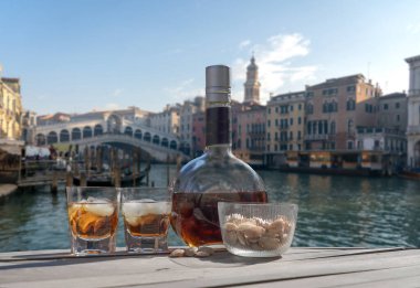Venedik 'te iki kişilik içki - iki bardak yalancı likör ve bir şişe - Rialto Köprüsü ile Venedik şehri panoraması