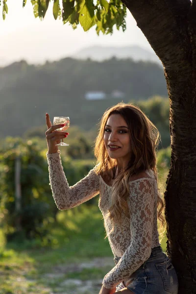 Kız Veneto tepelerindeki üzüm bağında Prosecco beyaz şarabı yudumluyor.