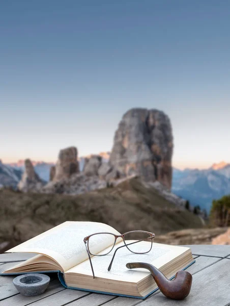 Kitap ve boru bir dağ manzarasının önünde - yüksek dağlarda tatil rahatlatma konsepti