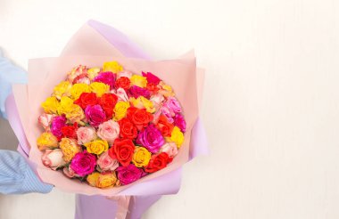 Erkeklerin elinde büyük bir buket parlak gül. Anneler Günü selamları. Yakın plan, seçici odak, yatay, kopyalama alanı