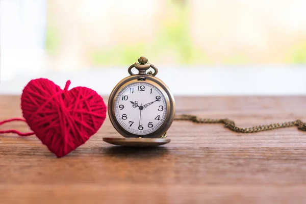 バレンタインデー、父・母の日すなわち永遠の誰かを表現するシンボル、木製の表面ウール心を編みネックレス アンティーク スタイルの懐中時計が特別な機会に愛します。. — ストック写真