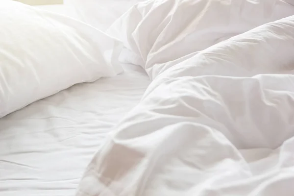 Manta desordenada arruga y almohada blanca en el dormitorio después de despertar por la mañana, de dormir en una larga noche, detalles de edredón y manta, una cama sin hacer en el dormitorio del hotel con manta blanca. —  Fotos de Stock