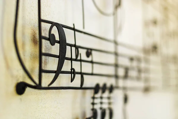 "F Clef" Bass Clef old steel on the old wall with music note blur on background, vintage style — Stock Photo, Image