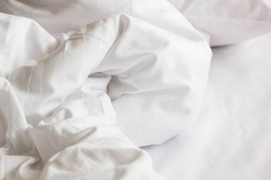 Beyaz yastık yatak ve üzerinden uzun bir gece, yorgan ve battaniye ayrıntılarını, otel yatak beyaz battaniye ile dağınık bir yatakta uyumak yatak odasında, kırışıklık dağınık battaniye ile.