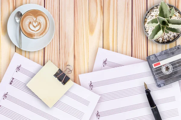 Notalar, kaktüs, dolma kalem, teyp kaseti ve ahşap masa üzerinde kahve latte — Stok fotoğraf