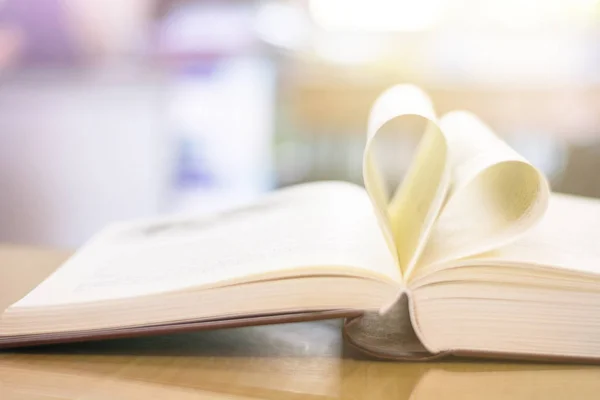 Corazón de una página de libro estilo vintage de cerca la forma del corazón del libro de papel con bokeh en luz suave en la mañana (fondo borroso) concepto para el día de San Valentín —  Fotos de Stock