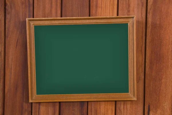 Empty green chalkboard with wooden frame on wooden wall, vintage wall texture background. — Stock Photo, Image