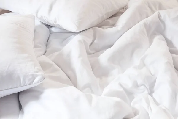 Bovenaanzicht van witte hoofdkussen op bed en met de rommelige deken rimpel in slaapkamer, slapen in een lange nacht. — Stockfoto