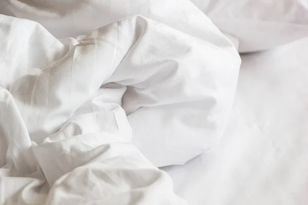 Almohada blanca en la cama y con la manta desordenada arruga en el dormitorio, de dormir en una larga noche, detalles de edredón y manta, una cama sin hacer en el dormitorio del hotel con manta blanca . — Foto de Stock