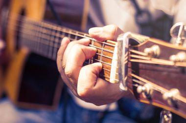 adamın closeup akustik gitar çalıyor, yumuşak vintage tarzı eller