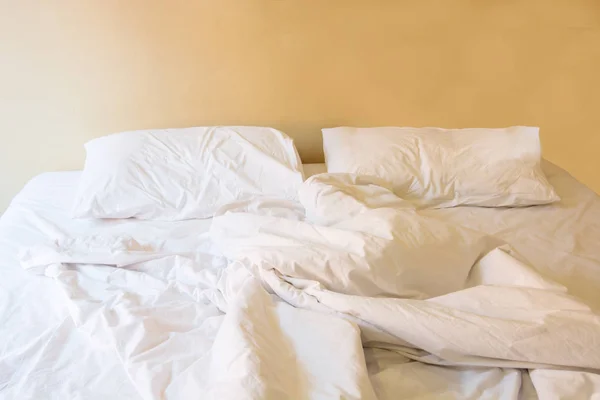 Almohada blanca en la cama y con la manta desordenada arruga en el dormitorio vintage —  Fotos de Stock