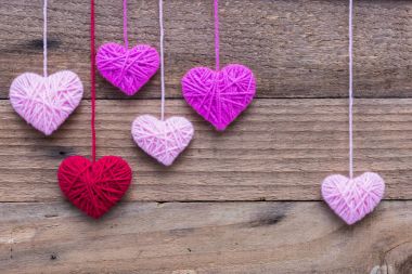 Kalp şekli üzerinde eski püskü yün örgü yapılan ahşap