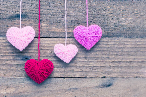 heart shape made from knitting wool on old shabby wooden