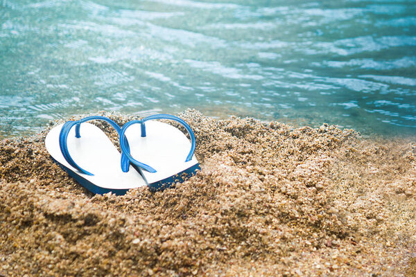 white and blue sandal on the sand beach, Summer holiday.