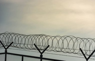 Dikenli tel çit kullanılan için koruma amaçlı, özellik ve hapis, hayır özgürlük, dikenli tel üzerinde ile mavi gökyüzü için hissediyorum endişesi çit.