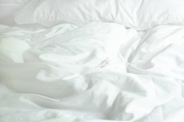 Beyaz yastık yatak ve yatak uzun bir uyku gece kış üzerinden, kırışıklık dağınık battaniye ile.