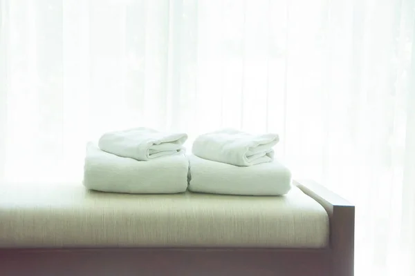 White Towels Were Laid On Sofa By The Window, With White Curtains In The Background.