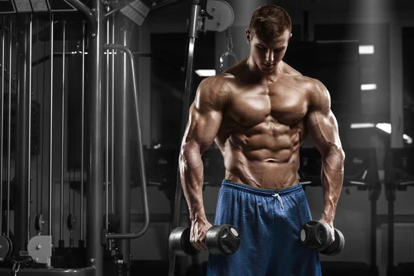 Hombre musculoso haciendo ejercicio en el gimnasio haciendo ejercicios con barra, fuertes abdominales masculinos desnudos del torso —  Fotos de Stock
