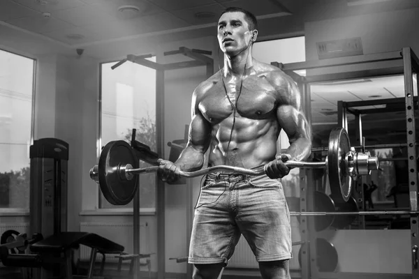 Muskulös man arbetande ute i gym gör övningar med skivstång, starka manliga abs — Stockfoto