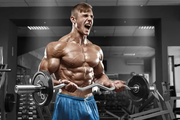 Gespierde man trainen in de sportschool doen oefeningen met barbell op biceps, sterke mannelijke naakte torso abs — Stockfoto