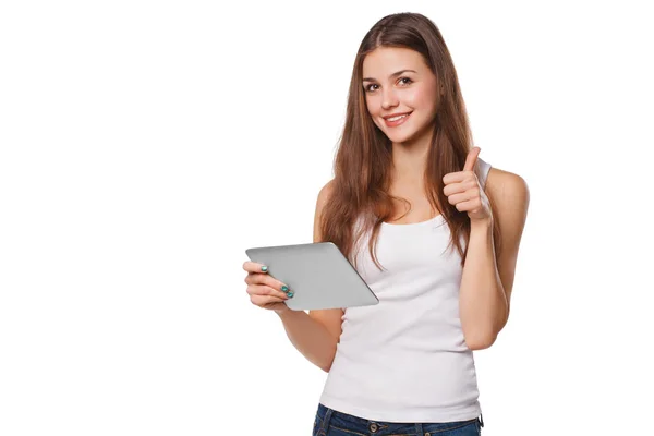 Ελκυστικό χαμογελαστό κορίτσι σε λευκό πουκάμισο χρησιμοποιώντας tablet που δείχνει τους αντίχειρες επάνω. Γυναίκα με το pc ταμπλετών, απομονώνονται σε λευκό φόντο — Φωτογραφία Αρχείου