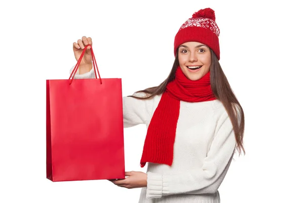 Surprised happy beautiful woman holding red bag in excitement, shopping. Christmas girl on winter sale with gift, isolated on white background — Stock Photo, Image