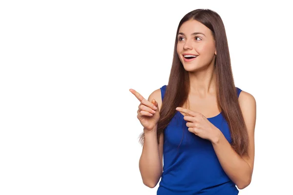 Smiling excited woman showing finger on copy space for product or text, isolated over white background — Stock Photo, Image