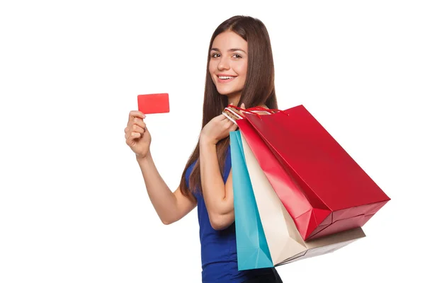 Χαμόγελο όμορφη γυναίκα ευτυχισμένη κρατώντας τσάντες για ψώνια και δείχνει κενό πιστωτική κάρτα, πώληση, απομονώνονται σε λευκό φόντο — Φωτογραφία Αρχείου