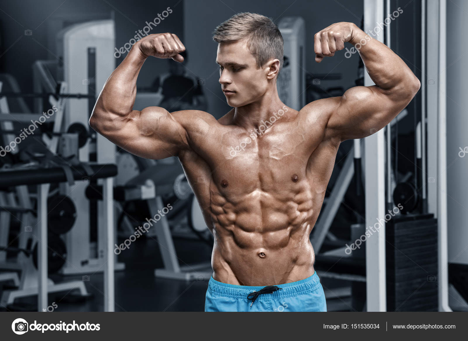 Sexy muscular man in gym working out, shaped abdominal. Strong male naked torso abs Stock Photo