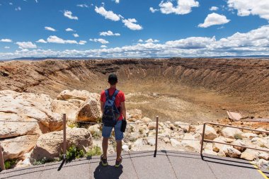 Travel in Meteor Crater, man hiker with backpack enjoying view, Winslow, Arizona, USA clipart