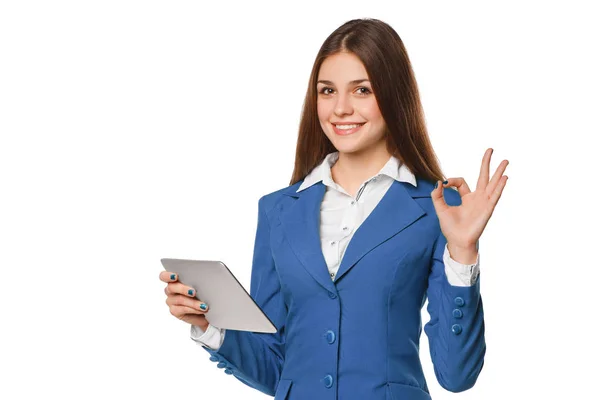 Lachende meisje in blauwe pak met behulp van de tablet goed teken tonen. Vrouw met de tablet pc, geïsoleerd op witte achtergrond — Stockfoto