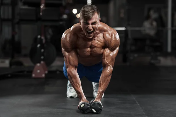 Homem musculoso trabalhando fora no ginásio fazendo exercícios, forte masculino nu torso abs — Fotografia de Stock