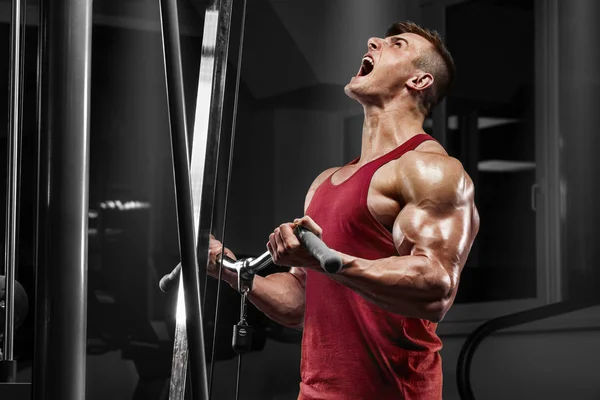 Muskulös man tränar i gym gör övningar, stark hane — Stockfoto