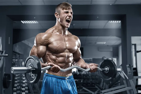 Spor salonunda egzersiz yapan kaslı bir adam. Güçlü erkek, çıplak karın kasları. — Stok fotoğraf