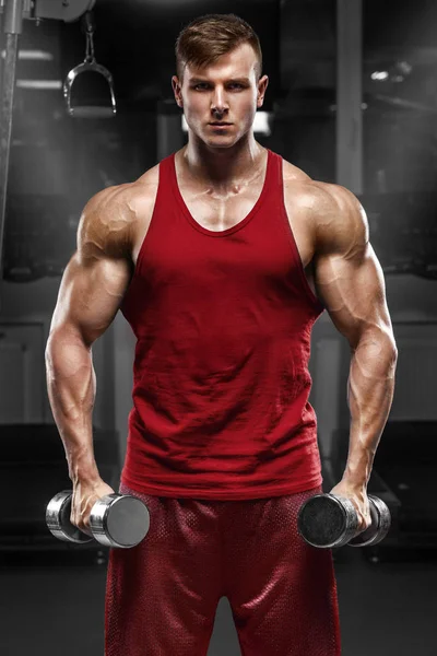 Muscular man working out in gym doing exercises, strong male — Stock Photo, Image
