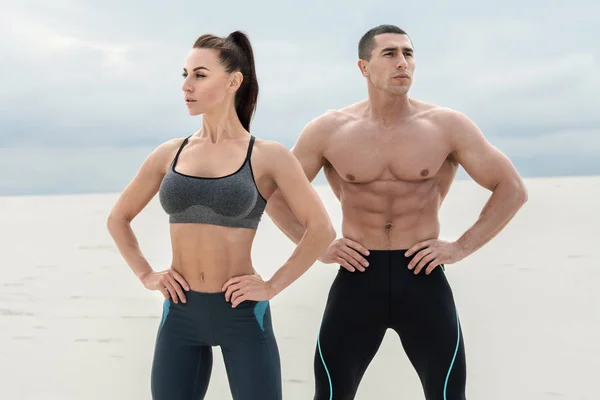 Sporty fitness couple showing muscle outdoors. Beautiful athletic man and woman, muscular torso abs — Stock Photo, Image