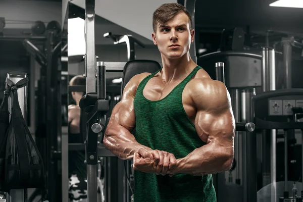 Мускулистый мужчина, тренирующийся в спортзале, сильный мужчина с большими бицепсами — стоковое фото