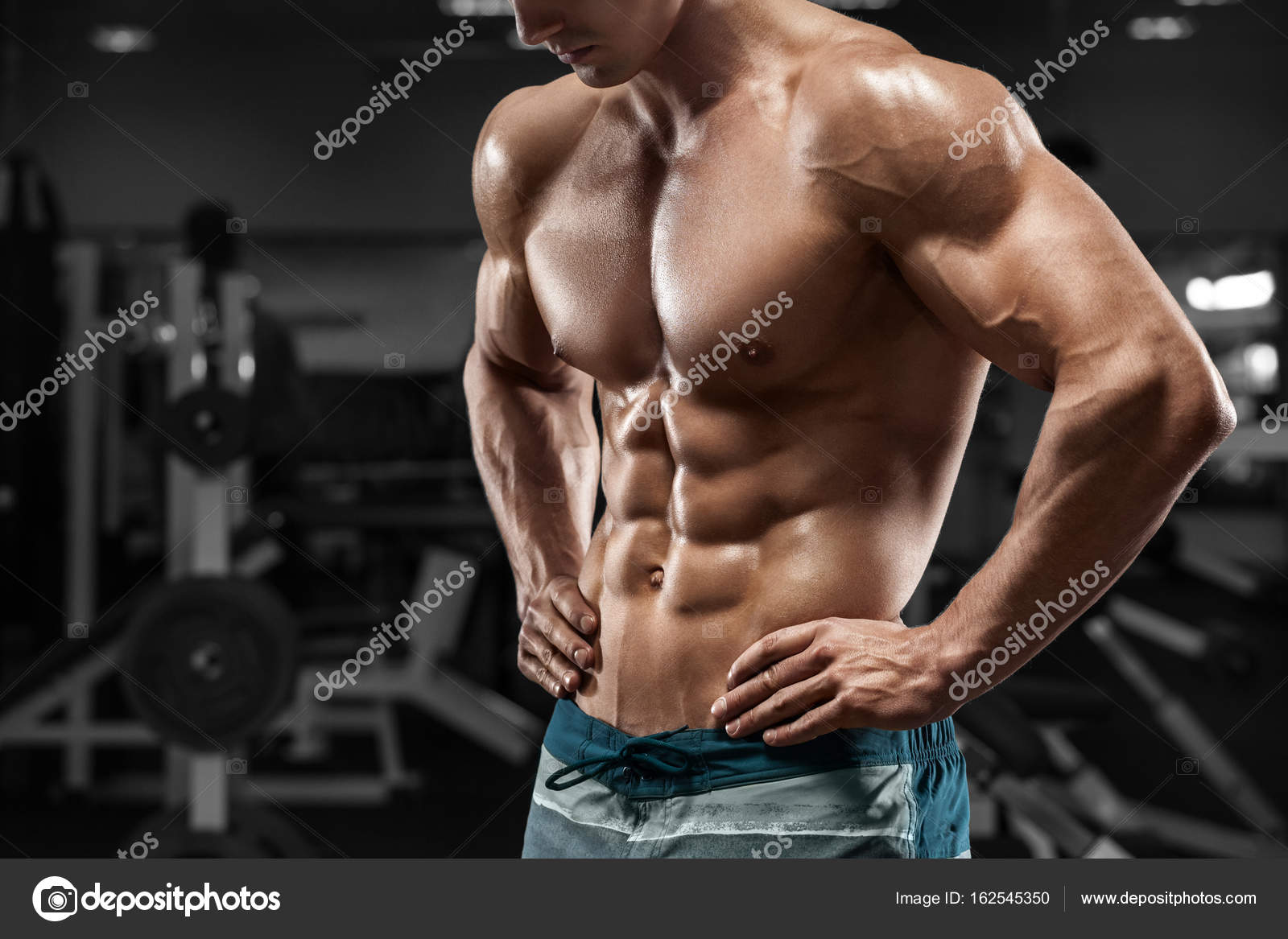 Homem musculoso abdominais no ginásio, em forma de abdómen. Forte