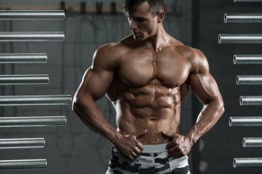 Spor salonunda poz kaslı adam kaslar, gösterilen. Güçlü erkek çıplak gövde abs, çalışma dışarı