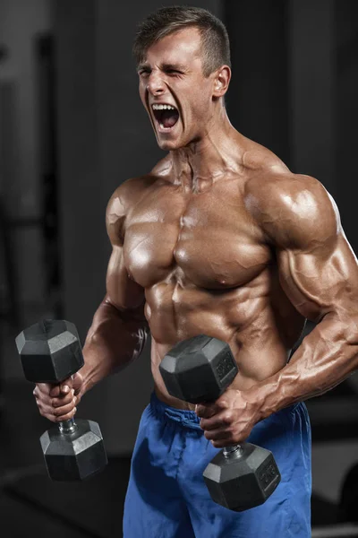 Hombre muscular haciendo ejercicio en el gimnasio haciendo ejercicios, fuertes abdominales masculinos desnudos del torso — Foto de Stock