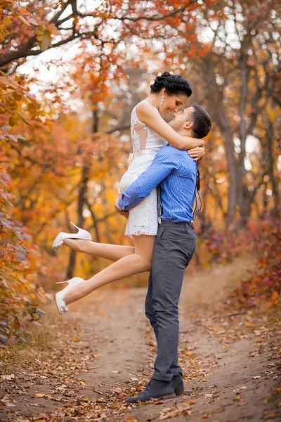 Šťastný pár objímat v podzimním parku. Usměvavá nevěsta a ženich v lese, venku — Stock fotografie