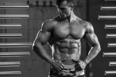 Spor salonunda poz kaslar, gösterilen yakışıklı kaslı adam. Güçlü erkek gövde abs, egzersiz