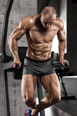 Paralel çubuklar, güçlü erkek çıplak gövde abs egzersizleri yaparken spor salonunda egzersiz kas adam