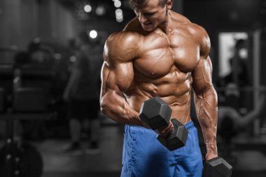 Kaslı adam ile halter, güçlü erkek çıplak gövde abs egzersizleri yapıyor spor salonunda egzersiz