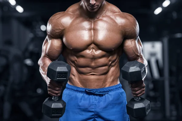 工作在健身房锻炼与哑铃 强烈的男性裸体躯干 Abs 的肌肉男 — 图库照片