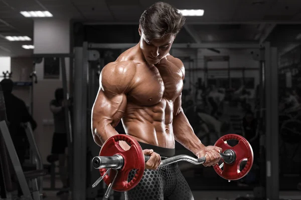 Kaslı adam ile halter, pazı, güçlü erkek çıplak gövde abs egzersizleri yapıyor spor salonunda egzersiz