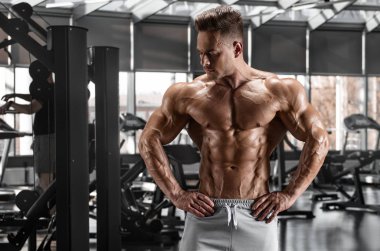 Spor salonunda kaslı adam egzersiz. Güçlü erkek çıplak gövde abs