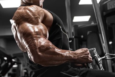 Vücut geliştirici adam spor salonunda çalışıyor. Güçlü erkek sırt egzersizi yapıyor.